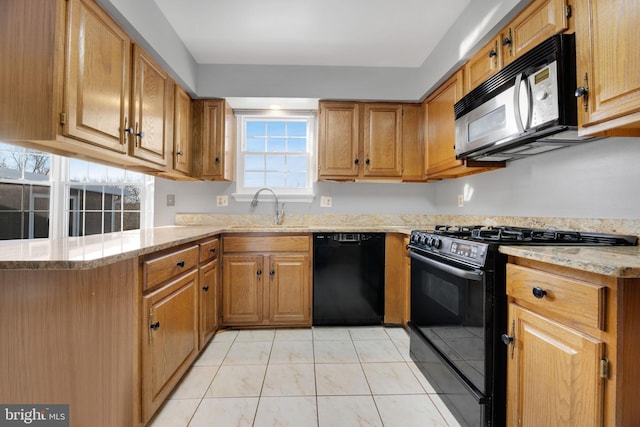 kitchen with kitchen peninsula, a healthy amount of sunlight, sink, and black appliances