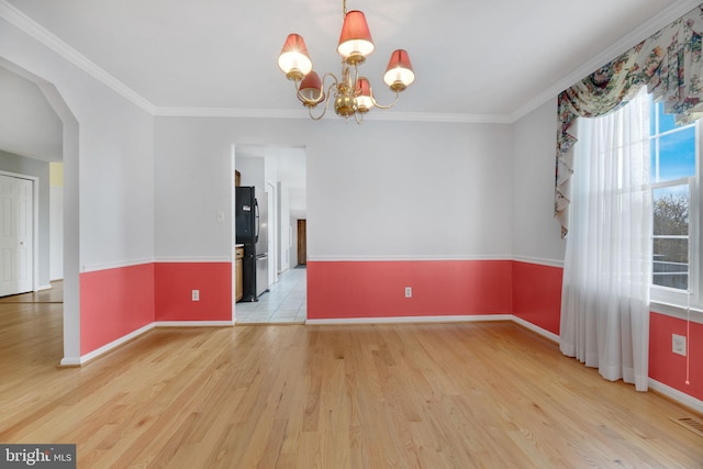 unfurnished room featuring light hardwood / wood-style flooring, a chandelier, and ornamental molding