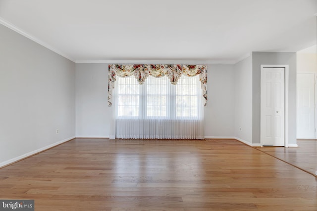 unfurnished room with light wood-type flooring and ornamental molding