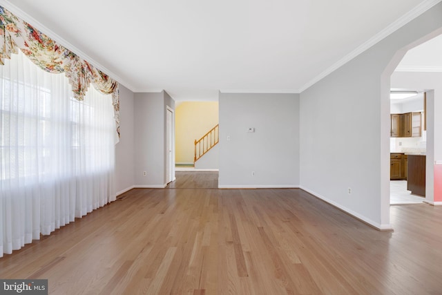 empty room featuring light hardwood / wood-style flooring and crown molding