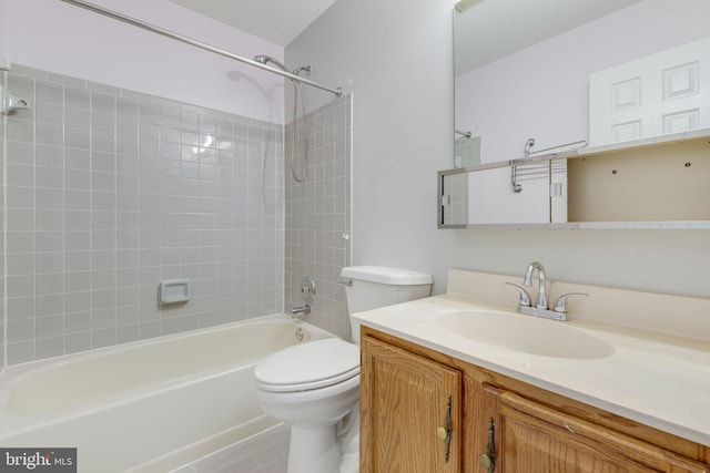 full bathroom with tile patterned floors, vanity, tiled shower / bath combo, and toilet