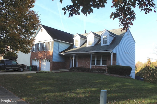 new england style home featuring a front yard and a garage