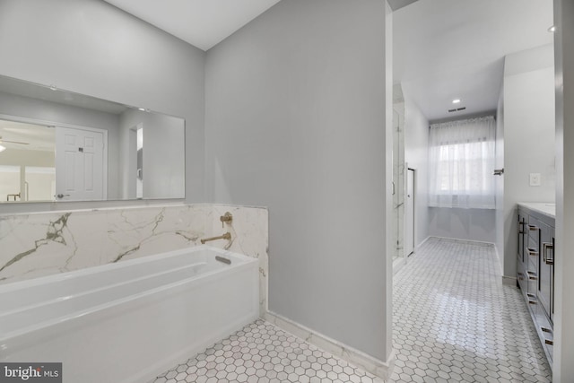 bathroom featuring tile patterned floors, vanity, and a washtub