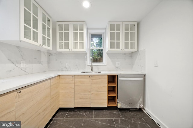 kitchen featuring stainless steel dishwasher, light brown cabinets, sink, and tasteful backsplash