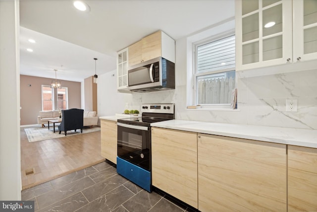 kitchen featuring light brown cabinets, range with electric cooktop, hanging light fixtures, dark hardwood / wood-style floors, and a notable chandelier