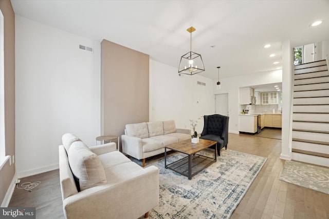 living room with a chandelier and light hardwood / wood-style floors