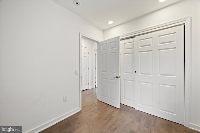 unfurnished bedroom featuring wood-type flooring and a closet