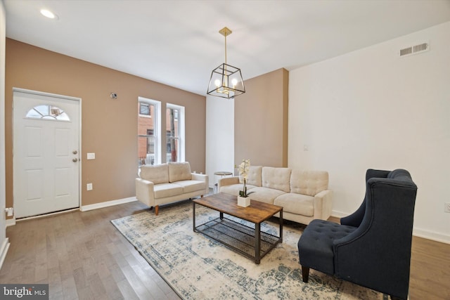 living room with a chandelier and wood-type flooring