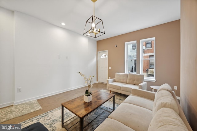 living room featuring wood-type flooring and an inviting chandelier