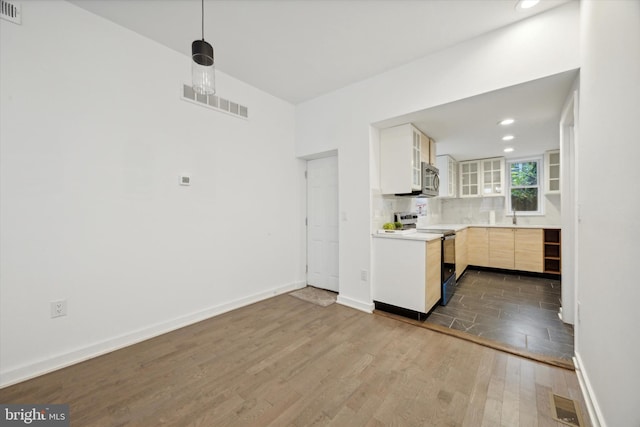 kitchen with sink, light brown cabinets, hanging light fixtures, white electric range oven, and wood-type flooring