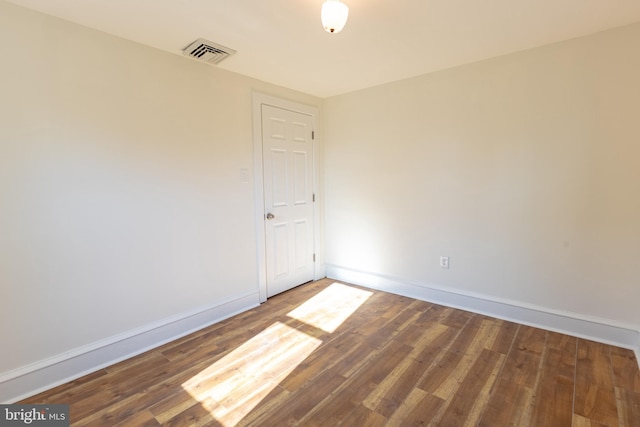 spare room featuring dark wood-type flooring