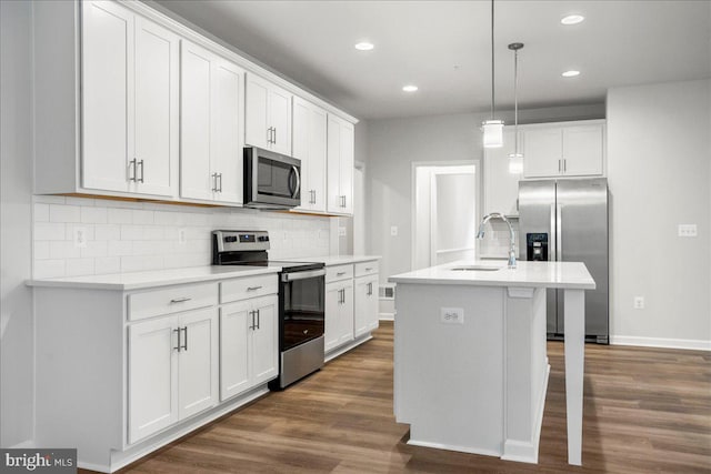 kitchen featuring sink, decorative light fixtures, a kitchen island with sink, white cabinets, and appliances with stainless steel finishes