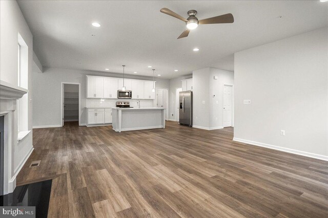 unfurnished living room featuring dark hardwood / wood-style flooring and ceiling fan