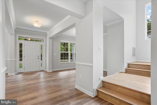 entryway with hardwood / wood-style floors and crown molding