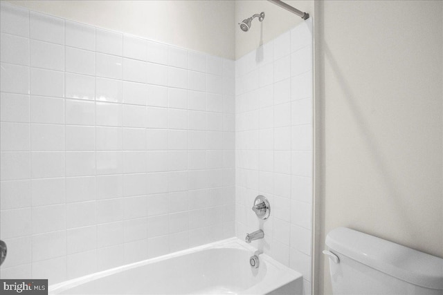 bathroom with tiled shower / bath combo and toilet