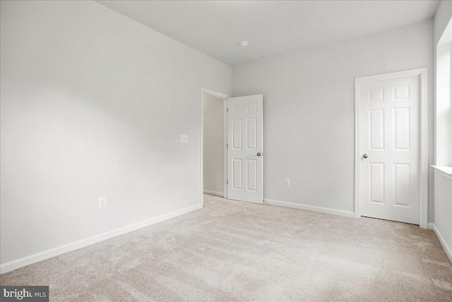 spare room featuring light colored carpet