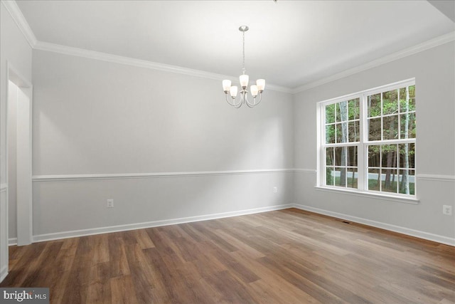 unfurnished room featuring ornamental molding, a notable chandelier, and hardwood / wood-style flooring