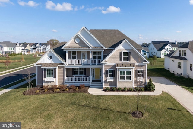 craftsman house featuring covered porch, a balcony, and a front yard