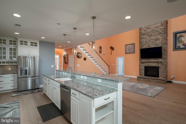 kitchen featuring sink, backsplash, pendant lighting, white cabinets, and appliances with stainless steel finishes