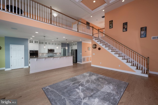 living room with a high ceiling and wood-type flooring