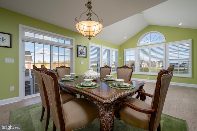 dining space featuring hardwood / wood-style floors, a wealth of natural light, and vaulted ceiling