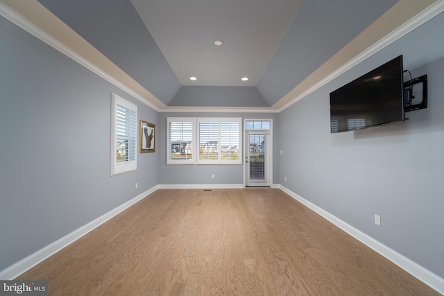 unfurnished living room featuring light wood-type flooring, vaulted ceiling, and ornamental molding