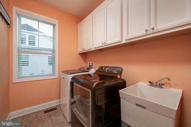 laundry room with cabinets, separate washer and dryer, and sink