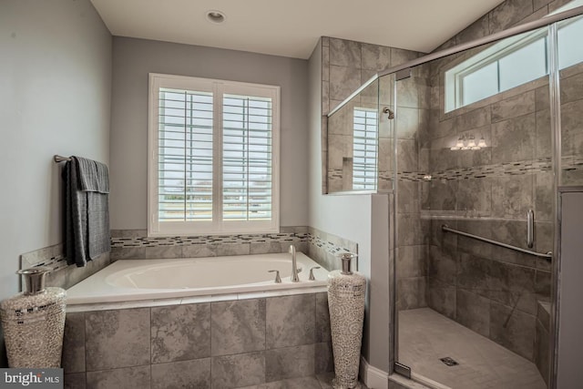 bathroom with shower with separate bathtub and a wealth of natural light