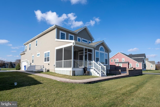 rear view of house featuring a sunroom, a garage, and a yard