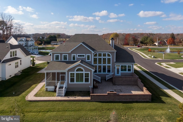 back of house featuring a sunroom, a yard, and a patio