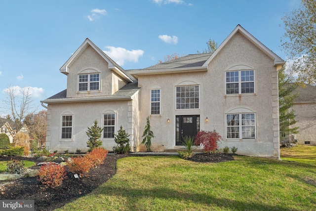 french provincial home with a front yard