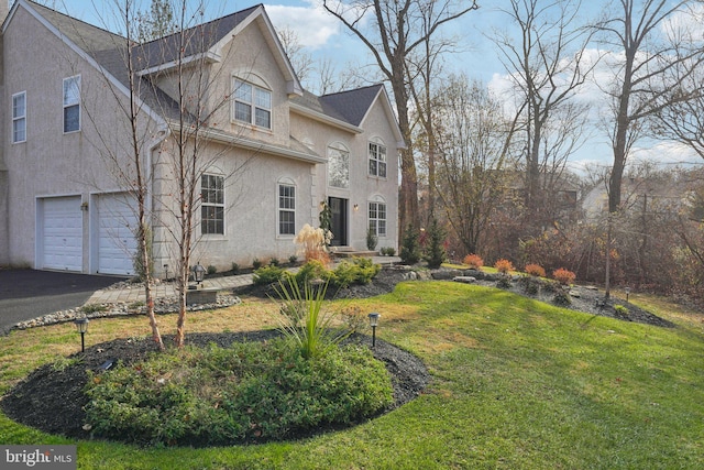 view of side of property featuring a garage and a lawn