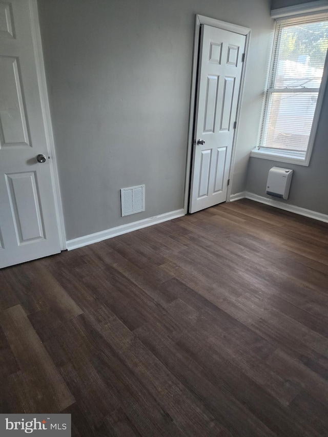 unfurnished bedroom with dark wood-type flooring