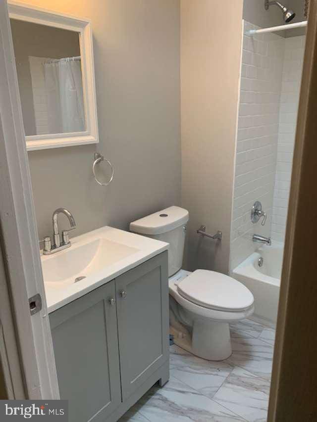 full bathroom featuring vanity, shower / tub combo, and toilet