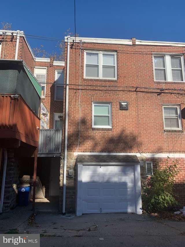 rear view of property with a garage