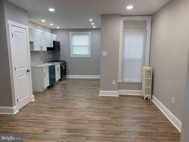 kitchen featuring radiator, white cabinets, and dark hardwood / wood-style floors