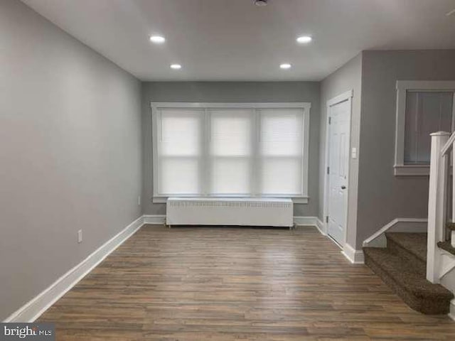 unfurnished room with radiator heating unit and dark wood-type flooring