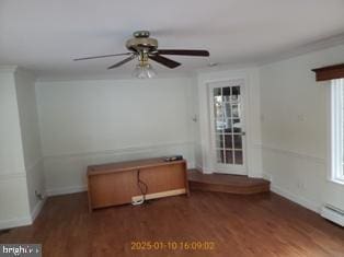 spare room with ceiling fan, a baseboard heating unit, a wealth of natural light, and dark hardwood / wood-style flooring