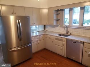 kitchen with tasteful backsplash, sink, hardwood / wood-style floors, and appliances with stainless steel finishes