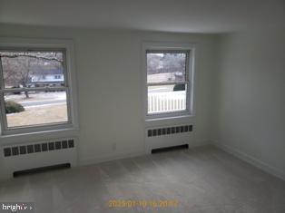 carpeted empty room with radiator