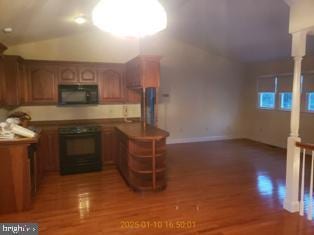 kitchen with dark wood-type flooring, range, and kitchen peninsula