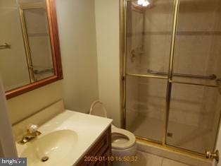 bathroom featuring vanity, tile patterned floors, toilet, and walk in shower