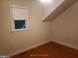 bonus room with dark wood-type flooring