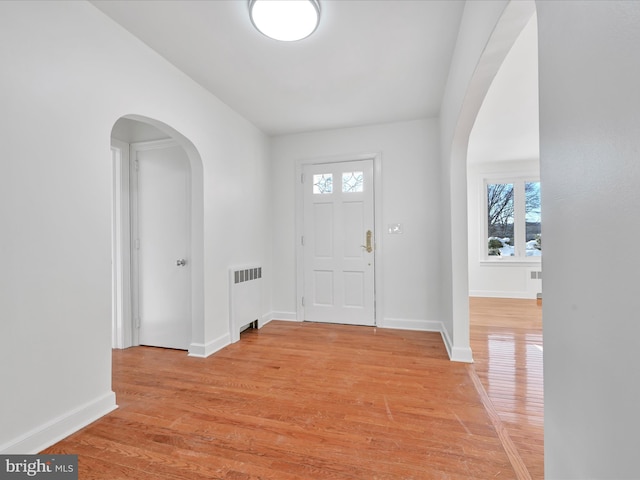 foyer entrance featuring radiator and light wood-type flooring