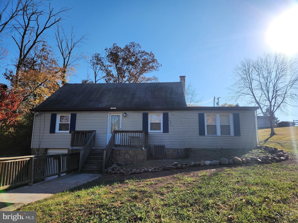 view of front facade with central AC and a front lawn