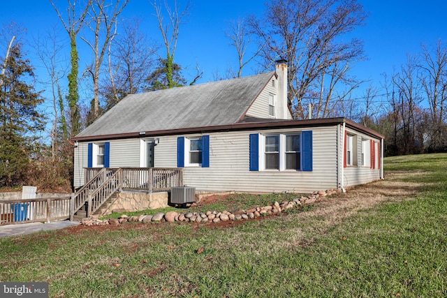 view of side of home featuring a lawn and cooling unit