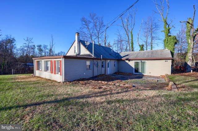 rear view of property featuring a lawn