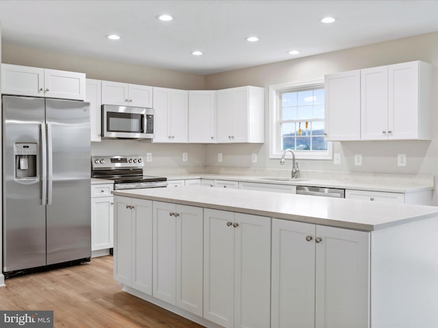 kitchen featuring light hardwood / wood-style floors, sink, white cabinetry, and stainless steel appliances