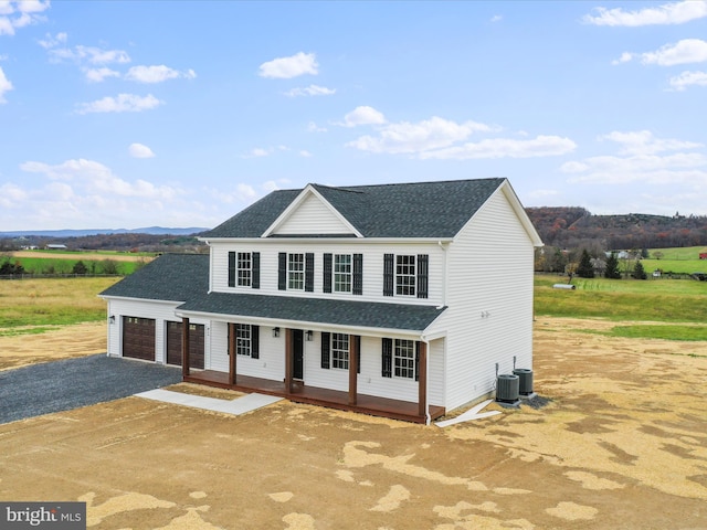 view of front of house featuring central AC, a mountain view, covered porch, and a garage