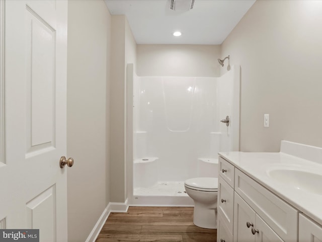 bathroom featuring toilet, hardwood / wood-style floors, vanity, and walk in shower